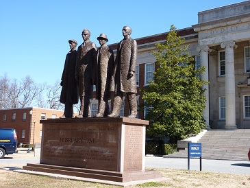 North Carolina A & T State University honors its four courageous students in a statue in front of the Dudley Building, on North Dudley Street, just off East Market.